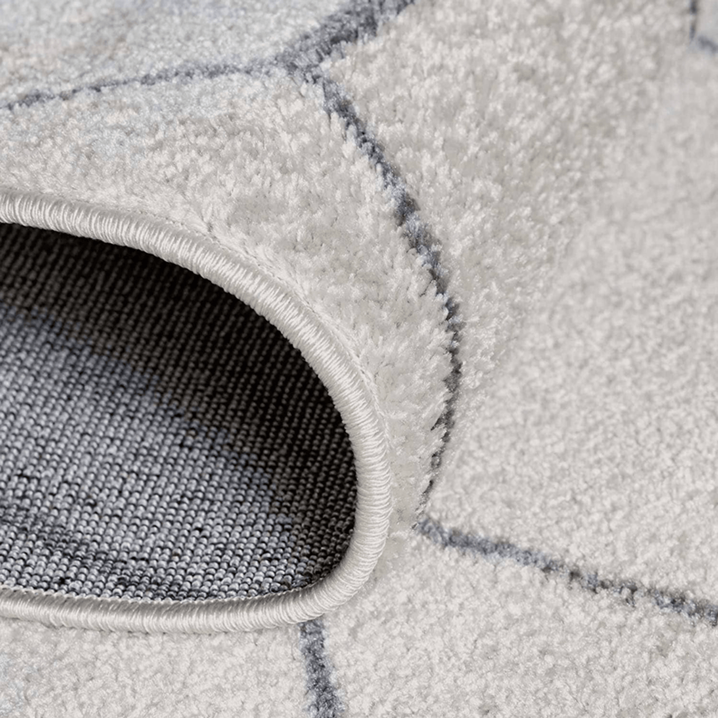 Close-up of a gray textured rug with geometric pattern