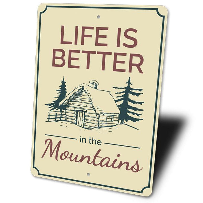 Sign with 'Life is Better in the Mountains' text and cabin illustration on a white background