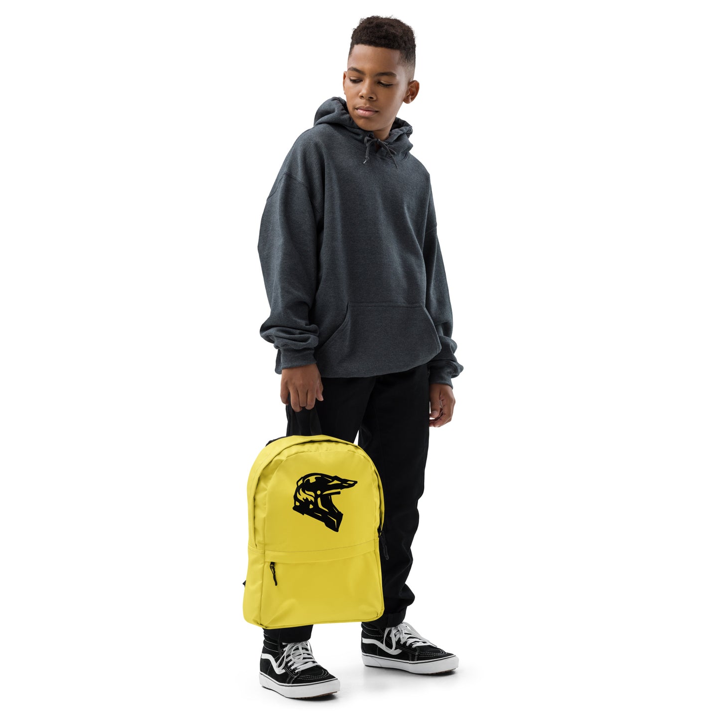 A person holding a yellow backpack with a black motorbike helmet design.