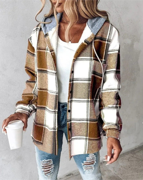 Person wearing a plaid shirt with a hood, holding a coffee cup against a plain background
