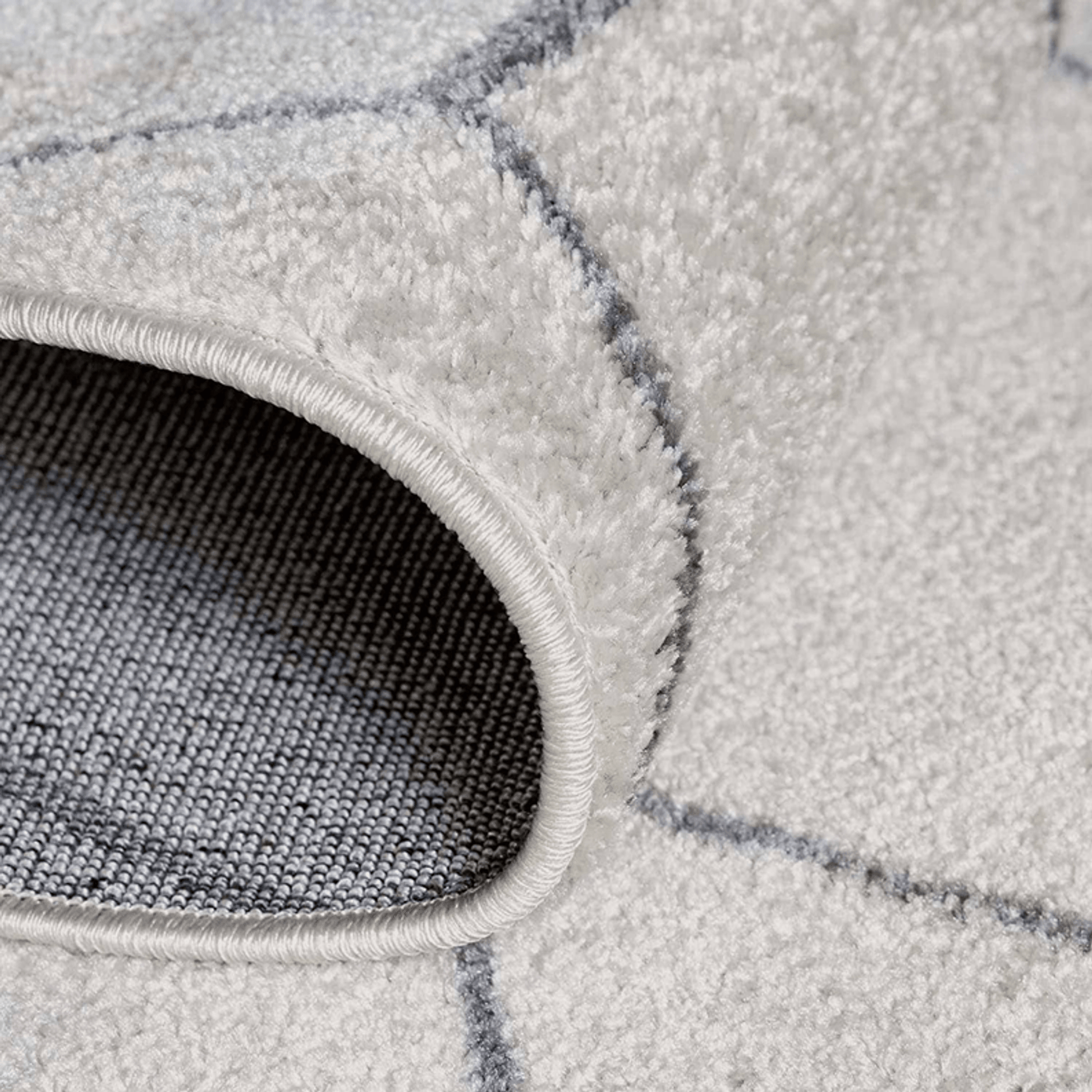 Close-up of a gray textured rug with geometric pattern