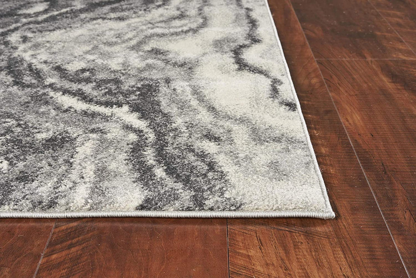 Gray and white marbled patterned rug on a wooden floor