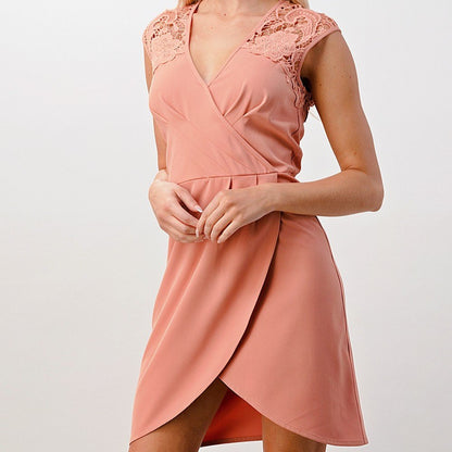 Woman wearing a pink dress with lace details on a white background