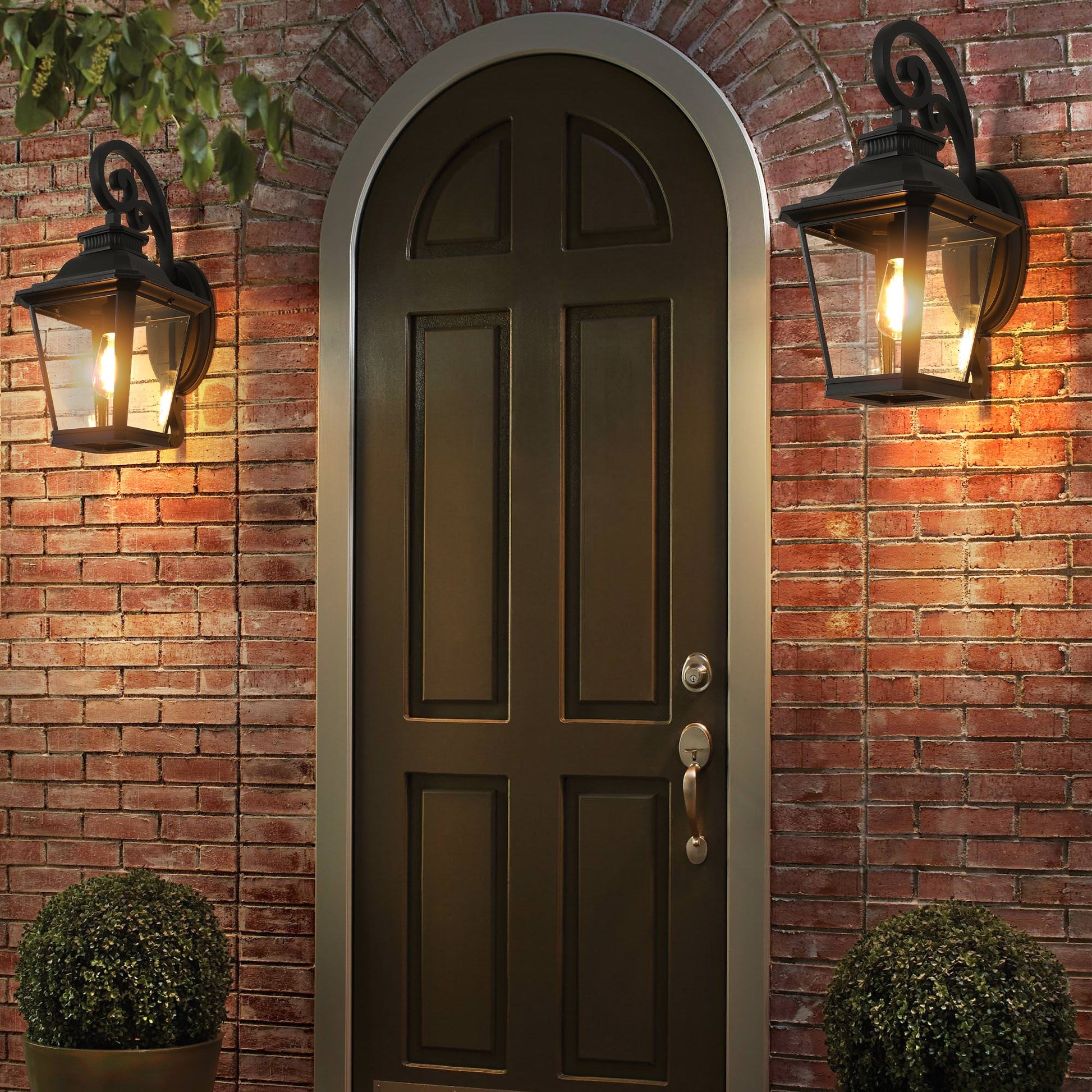 Dark wooden door with wall-mounted lanterns on a brick wall