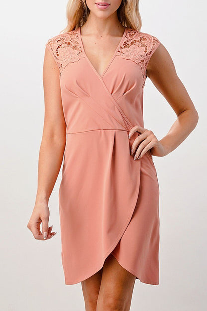 Woman wearing a pink dress with lace details on a white background