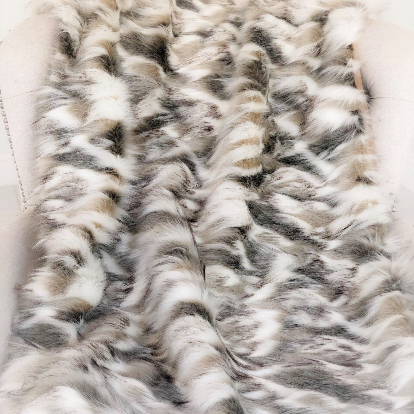 Close-up of a fur blanket with a wavy pattern on a white background