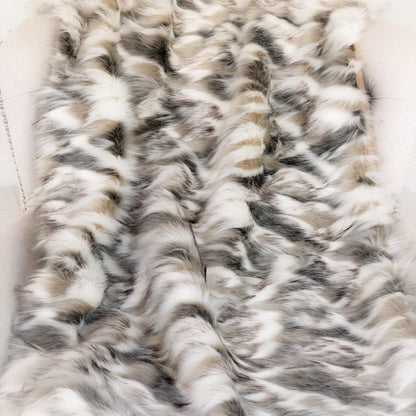 Close-up of a fur blanket with a wavy pattern on a white background