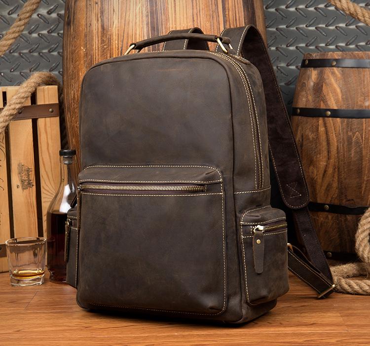 Brown leather backpack on a wooden surface with a rustic background