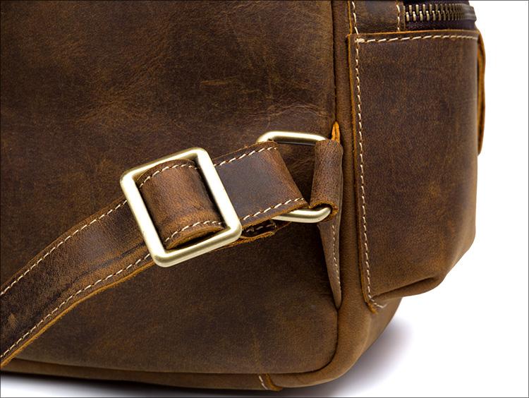 Close-up of a brown leather bag with a gold buckle on a white background