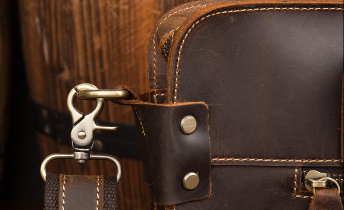 Close-up of a brown leather bag with metal hardware